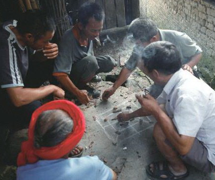 陰雨天,三五瑤民聚在一起玩瑤族傳統(tǒng)“趕豬棋”。